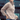 Woman wearing a beige knitted sweater with buttons in an urban setting