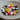 Colorful assortment of Stitch Stoppers by Fox & Pine Stitches in a bowl, featuring rubber duck and animal designs for knitting.