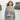 Model wearing a sweater from Aran by Marie Wallin with Fairisle motifs, standing by the sea.