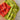 Bright knitted cloths showcasing Beaded Colourwork technique with bold patterns on a wooden surface.
