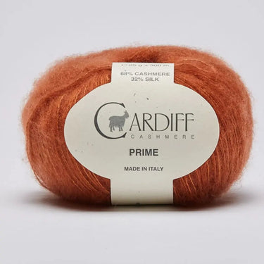 Ball of orange yarn with a Cardiff label on a light gray background