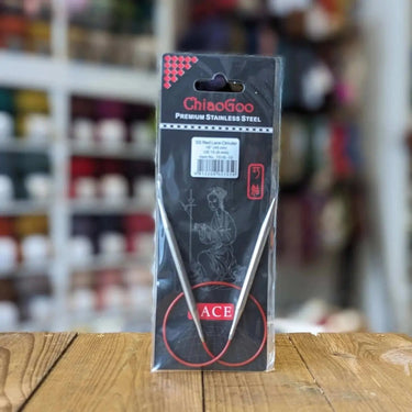 Chiaogoo fixed circular Knitting Needles in a pack on a wooden box at knit with me yarn shop