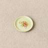 Cocoknits Magnetic Notions Dish holding colorful metal stitch markers on a linen surface.