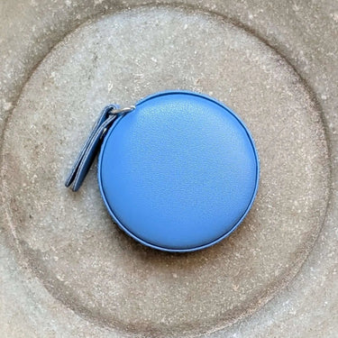 Blue retractable Colourful Tape Measure from Fox & Pine Stitches on a grey surface, ideal for knitting and sewing projects.