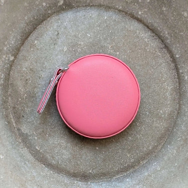 Pink Colourful Tape Measure in round case on textured surface
