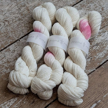 Close-up of skeins from Contemplation II Cowl Knitting Kit by Chroma Nima, hand dyed organic cashmere yarn with pink accents.