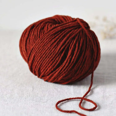 Cyrano large soft round 5-ply yarn made from carded wool in natural brown tone on white surface