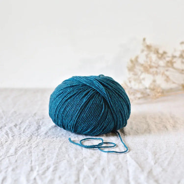 Gilliatt yarn ball in teal, made from French Mérinos d'Arles and black Portuguese merino, showcasing its fluffy texture and stitch definition.
