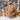 Stuffed Alpaca animal by Inkari on display, showcasing its fluffy brown coat, surrounded by colorful yarn skeins.