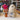 Stuffed Alpaca toy by Inkari, fluffy and soft, displayed next to colorful yarn in a cozy shop setting.