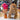 Inkari Stuffed Alpaca Animal in brown, displayed with colorful wool in background and decorative vase