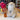 Stuffed Alpaca by Inkari next to floral display, showcasing soft and cuddly design in a craft shop setting.