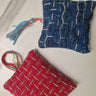 Two woven pouches, one red and one blue, on a marble surface.