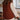 Person wearing a brown knitted vest in a kitchen setting