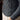 Close-up of a person wearing a blue knitted sweater with intricate patterns.