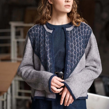 Woman wearing a blue and gray patterned cardigan in an indoor setting