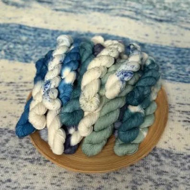 Yarn Advent Calendar featuring blue and white mini skeins on a bamboo plate with ocean-themed background.