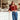Woman in a red sweater and blue jeans standing in a cafe.