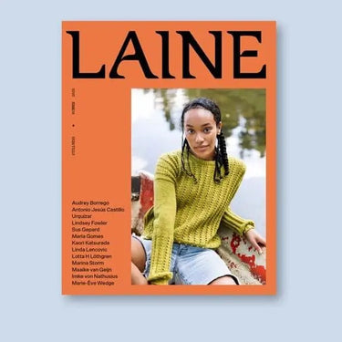 Cover of Laine Magazine Issue 25 featuring a model in a green knitted sweater by a lakeside, highlighting Finnish summer tranquility.