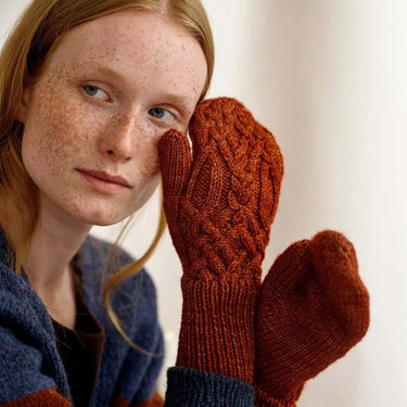 Model wearing knitted mittens from Laine Magazine Issue 27, showcasing winter designs with bold cables and textures.