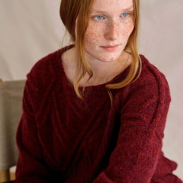 Model wearing red knit sweater from Laine Magazine Issue 27 - Winter PRE-ORDER featuring winter knitting designs.