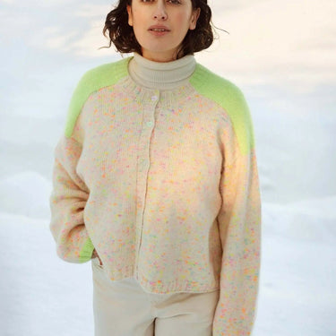 Woman wearing a colorful sweater featured in Laine Magazine Issue 27 - Winter PRE-ORDER, highlighting bold knitting designs.