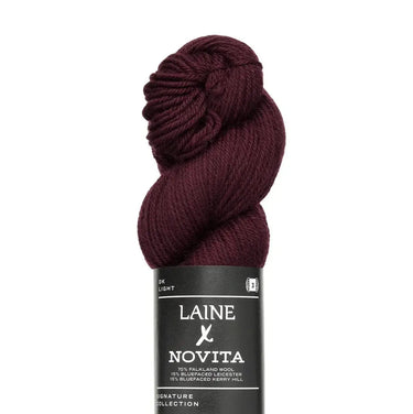 Laine x Novita DK yarn skein in deep burgundy, featuring high-quality British fibres of Falkland wool and Bluefaced breeds.