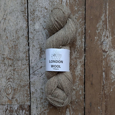 Skein of London Wool yarn from London City Farm Project, featuring rare sheep breeds' fleece, on a rustic wooden background.