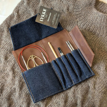 Lykke Weekender Knitting Needle Travel Case in denim and vegan leather, open with knitting needles and crochet hooks inside.