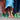 Colorful socks with striped patterns worn by three people, showcasing playful and vibrant fashion on a concrete surface.