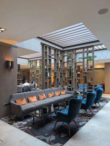 Knit social event at Clayton Hotel Chiswick lounge area with blue chairs and modern decor.