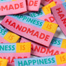 Colorful woven labels with text on a white background