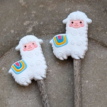 Cute llama Stitch Stoppers by Fox & Pine Stitches on knitting needles, perfect for keeping knitting projects secure.