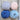 Four balls of yarn in pale pink, lavender, deep blue, and light blue on a rustic wooden surface.