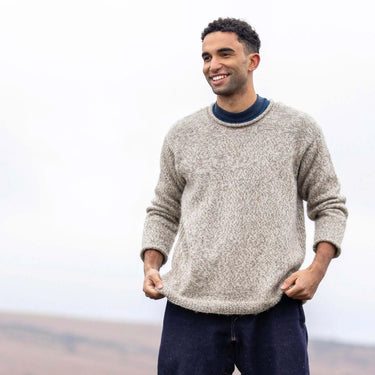 Smiling man wearing a knit sweater, highlighting 'A Knitter's Guide' wool versatility.