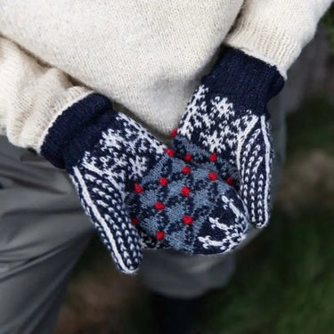 Person wearing hand-knitted Finnish mittens from Tukubook collection, featuring intricate patterns and vibrant colors.