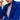 Person wearing a blue knitted cardigan with a blurred background. Tukubook knitting book