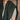 Person wearing a green knitted shawl over a beige sweater against a wooden background, Tukubook knitting book