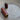 Wooden darning needle case with 3 metal darning needles on table.